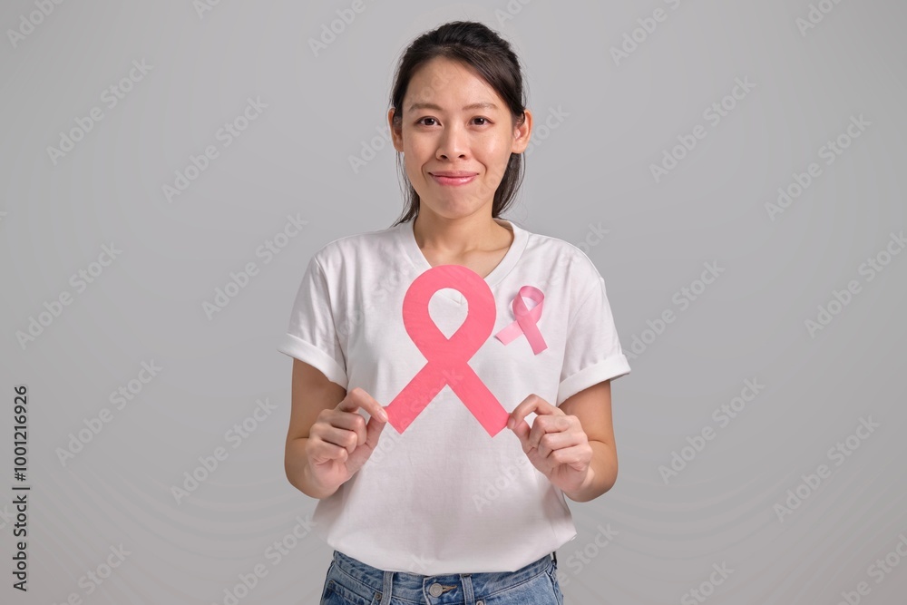 Young woman holding Pink Ribbon Oncology Awareness Symbol. Breast cancer awareness concept. Young woman holding Pink Ribbon Oncology Awareness Symbol. Breast cancer awareness concept.