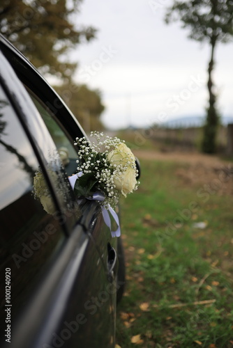 Bridal bouquet with white roses on a car, symbolizing the beginning of a new journey