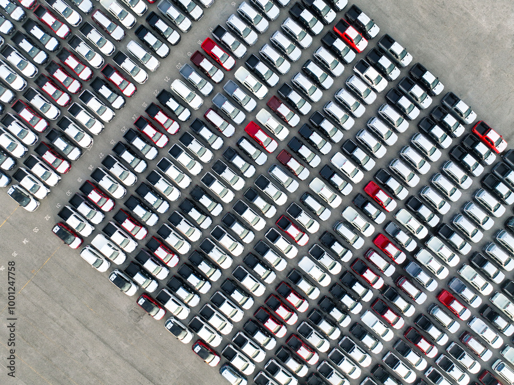 Aerial view of new cars stock at factory parking lot. Above view cars parked in a row. Automotive industry. Logistics business. Import or export new cars at warehouse. Big parking lot at port terminal Aerial view of new cars stock at factory parking lot. Above view cars parked in a row. Automotive industry. Logistics business. Import or export new cars at warehouse. Big parking lot at port terminal