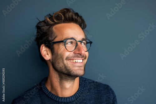 Smiling man with glasses looking away from the camera.