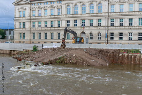 Yellow excavator on the bank of the river Svratka, Brno, Czech republic, floods after storm Boris, September 15, 2024.