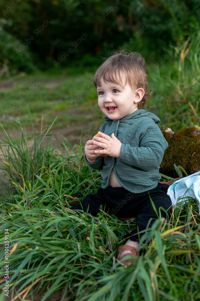 A boy on the shore in the green grass has a picnic A boy on the shore in the green grass has a picnic
