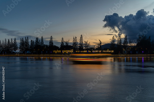 A ship light trails on the Praek Tuek Chhu River in Kampot in Cambodia at sunset photo