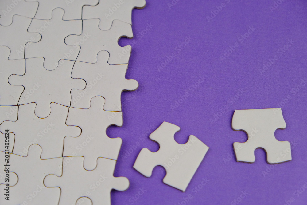 Fototapeta premium white jigsaw puzzle with missing puzzle for a text template. Above photo of isolated on the purple background