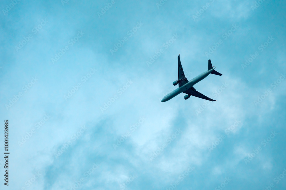 Fototapeta premium An airplane flying in a cloudy sky