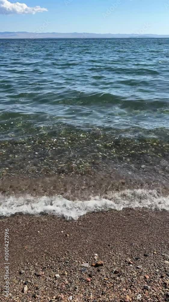 Surf waves on a pebble beach on a sunny day. 4K footage Surf waves on a pebble beach on a sunny day. 4K footage