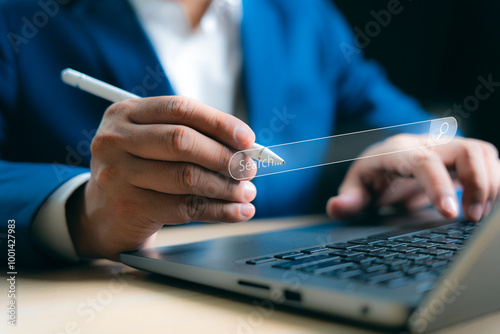 Businessman hands holding pen working with laptop computer device on office desk. Using search web browsing Internet data Information network. Business digital technology concept.