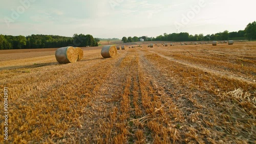 Close-up of large hay bales resting in a harvested field during golden hour at sunset