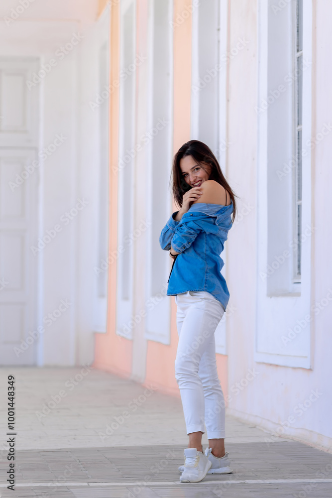 Young woman in a vibrant city alley. A young woman stands playfully in a vibrant alley, wearing a blue shirt and white pants, enjoying a sunny day outdoors. Young woman in a vibrant city alley. A young woman stands playfully in a vibrant alley, wearing a blue shirt and white pants, enjoying a sunny day outdoors.