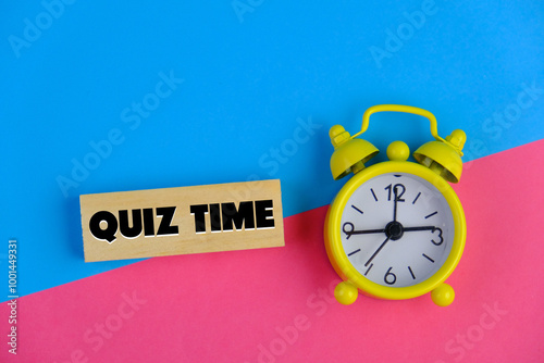 the words Quiz Time beside mini alarm clock on a plain background. the concept of answering quizzes or quiz games. text space photo