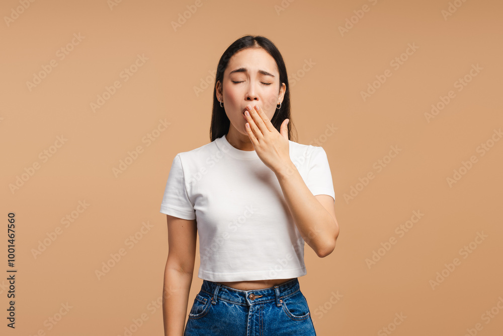 Young asian woman yawning and covering her mouth with hand Young asian woman yawning and covering her mouth with hand