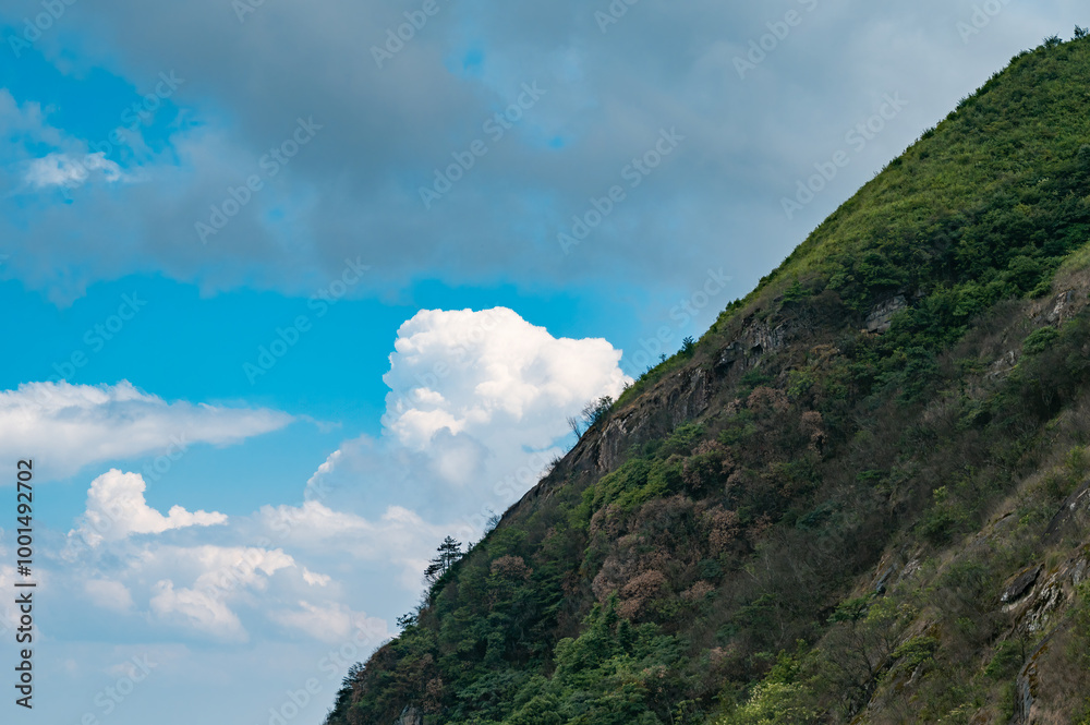 Mountain slopes and blue sky with white clouds