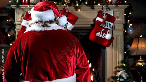 Santa Claus shares a festive moment in a cozy room with holiday decorations and stockings hung by the fireplace