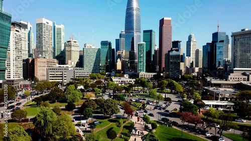 People enjoying a sunny day in a Houston park surrounded by skyscrapers and greenery