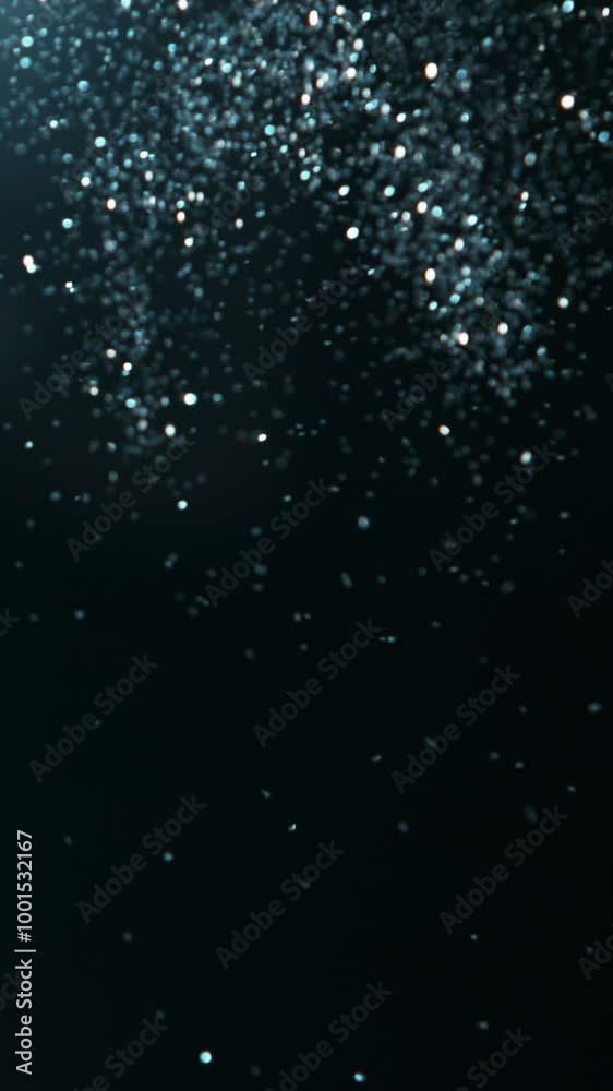 Super slow motion of glittering blue particles on black background. Shallow depth of focus. Filmed on high speed cinema camera, 1000 fps. Vertical Composition.
