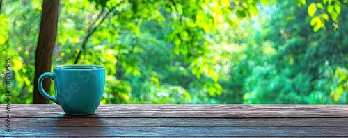 A blue coffee cup on a wooden table with a blurred green background.