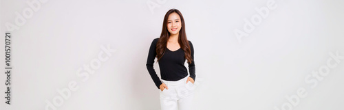 A portrait of a Southeast Asian woman wearing a black long-sleeve T-shirt and white skinny pants.