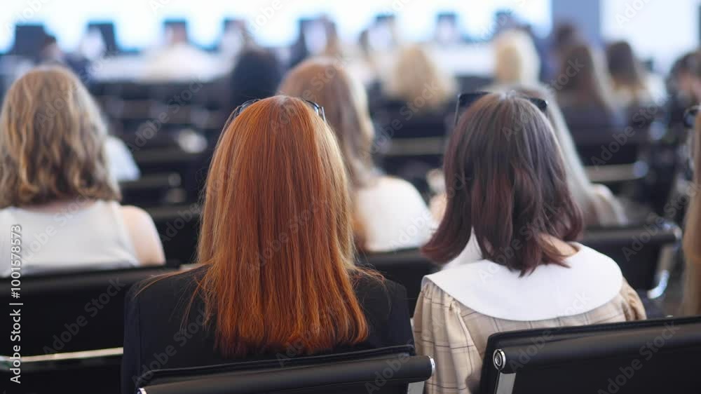 Female participants audience at the symposyum meeting, attendees in conference room hall listens to lecturer, group of women on a congress together listen to speaker on a stage at master-class Female participants audience at the symposyum meeting, attendees in conference room hall listens to lecturer, group of women on a congress together listen to speaker on a stage at master-class