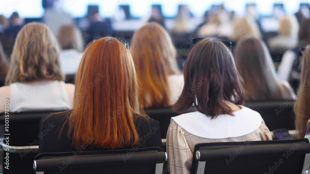 Female participants audience at the symposyum meeting, attendees in conference room hall listens to lecturer, group of women on a congress together listen to speaker on a stage at master-class Female participants audience at the symposyum meeting, attendees in conference room hall listens to lecturer, group of women on a congress together listen to speaker on a stage at master-class