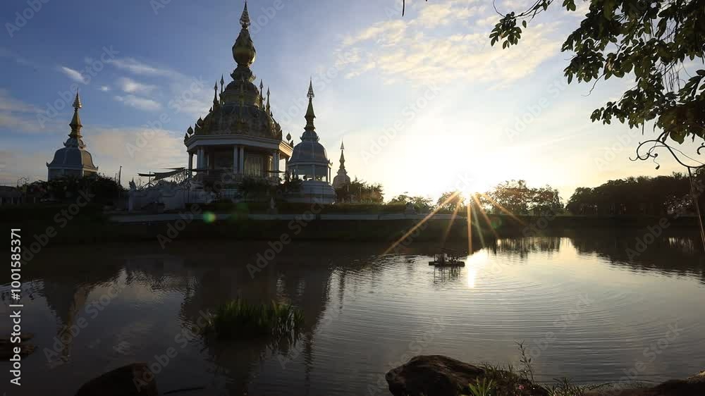 4K video background of the morning sun light overlooking the old pagoda in the middle of the water(Wat Thung Setthi) in Khon Kaen of Thailand, is beautiful and the blur of the wind blows. 4K video background of the morning sun light overlooking the old pagoda in the middle of the water(Wat Thung Setthi) in Khon Kaen of Thailand, is beautiful and the blur of the wind blows.