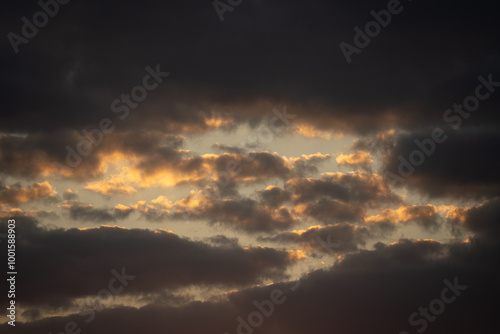 yellowish-blue evening sky against a backdrop of big clouds