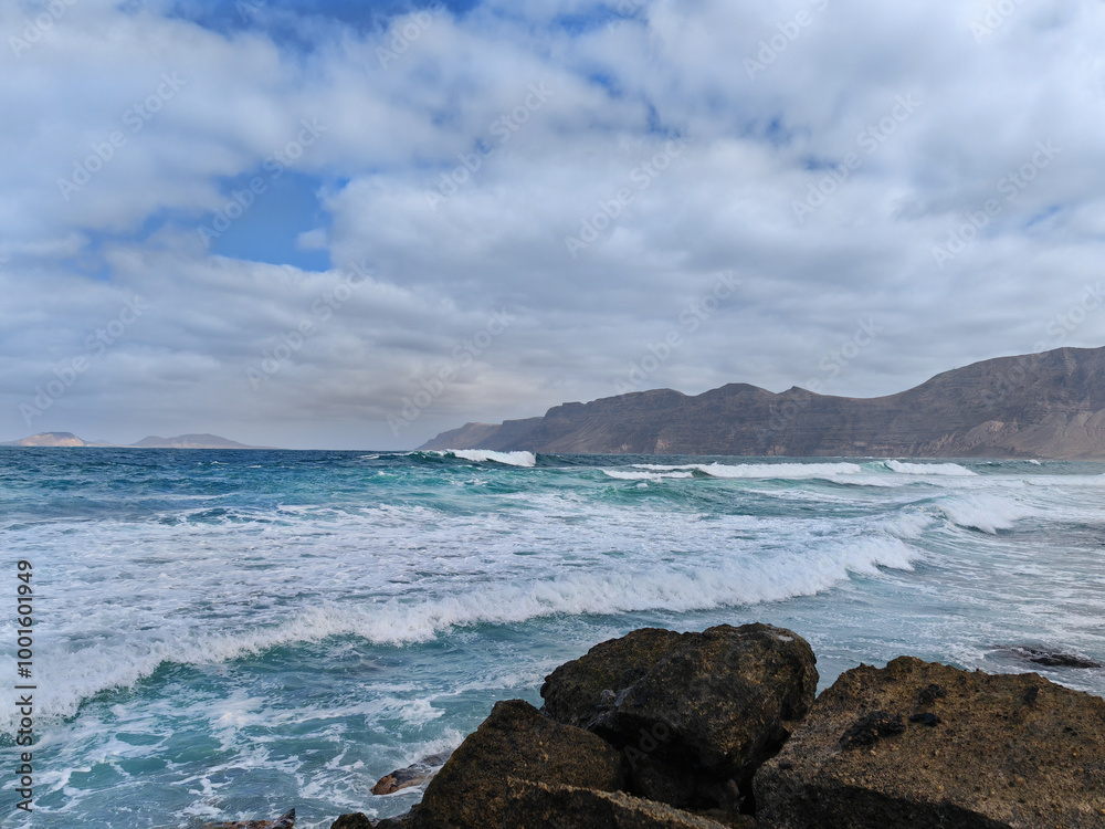 Landscape with the Atlantic Ocean in the mist from Famara beach and Graciosa Island in the background Landscape with the Atlantic Ocean in the mist from Famara beach and Graciosa Island in the background