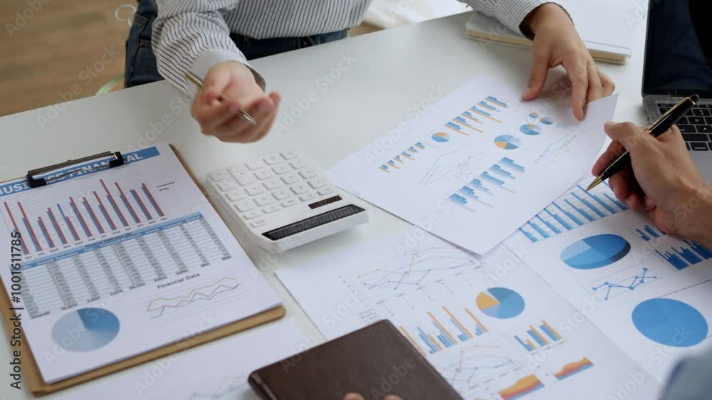 Business people having a discussion about financial data, analyzing charts and using a calculator Business people having a discussion about financial data, analyzing charts and using a calculator
