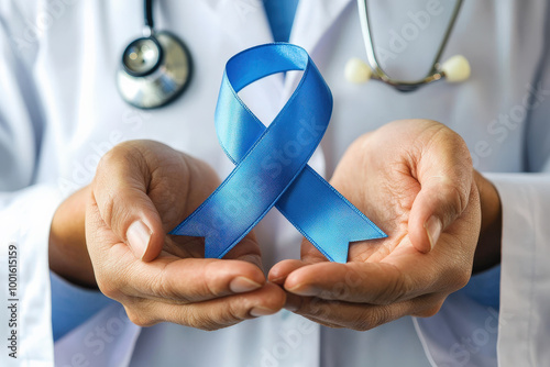 manos de un hombre medico con bata blanca y estetoscopio sosteniendo un lazo azul, simbolo de la lucha contra el cancer y enfermedades masculinas
