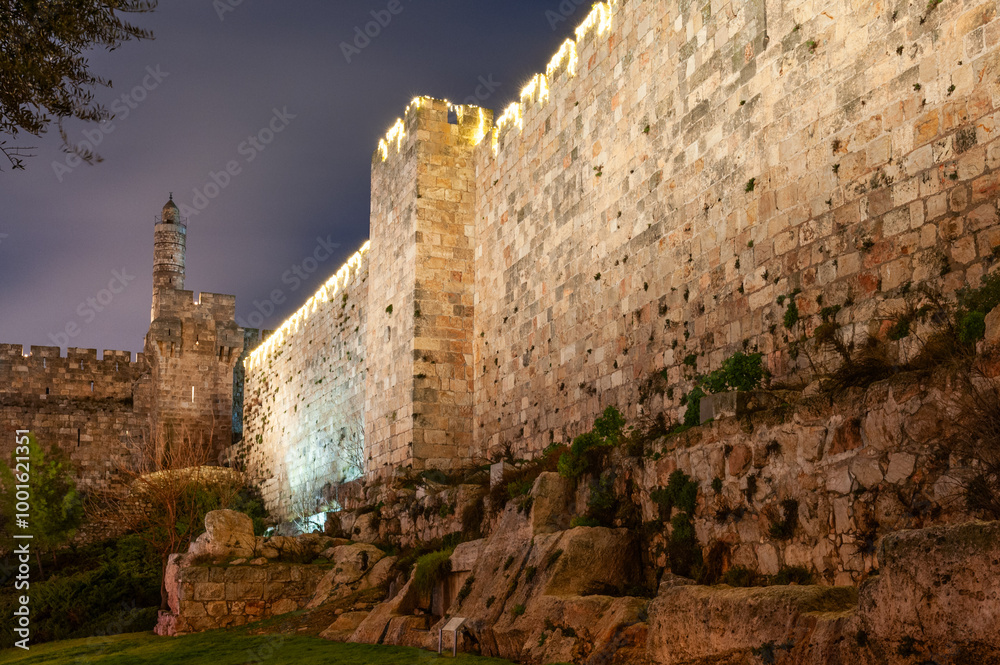 Fototapeta premium View of the Tower of David and western expanse of walls and ramparts of the Old City at twilight in Jerusalem. .