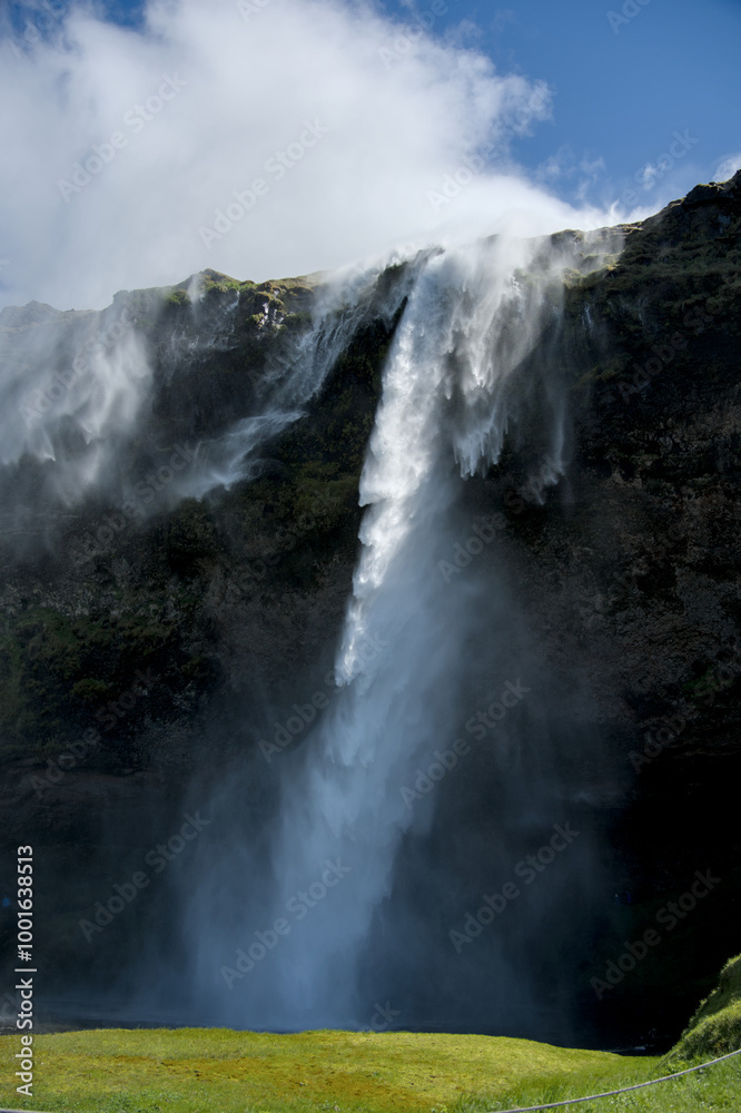 The waterfall of Seljalandsfoss in Iceland from behind the water The waterfall of Seljalandsfoss in Iceland from behind the water
