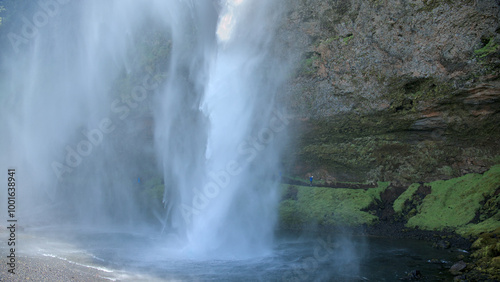 The waterfall of Seljalandsfoss in Iceland from behind the water