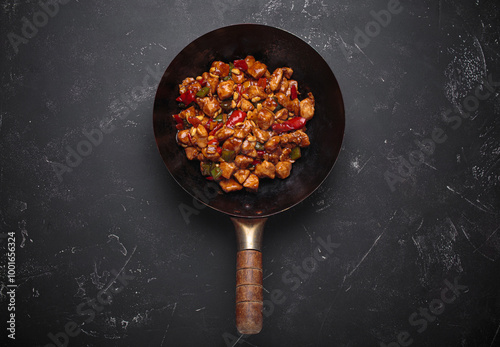 Wok is filled with savory kung pao chicken with tender chicken, crunchy peanuts and vibrant vegetables, all coated in a flavorful sauce photo