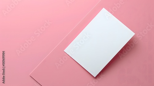 White blank card on pink background. Minimalist flat lay design with copy space. Perfect for wedding invitations, greeting cards, or marketing materials for stationery products.