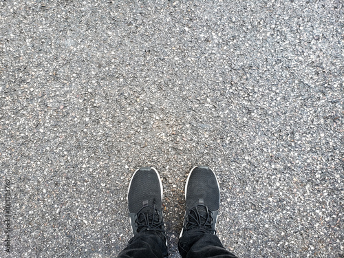 Foot and legs seen from above. top view of feet standing on ground photo