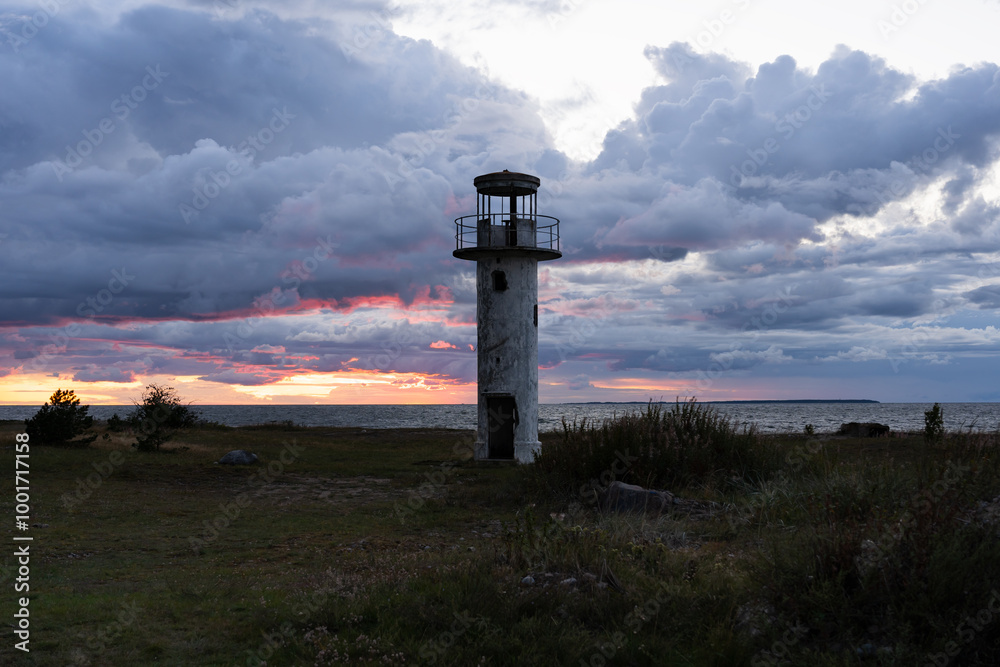 The old Neeme lighthouse against a stormy sky at sunset. Estonian nature, north coast of Baltic Sea. The old Neeme lighthouse against a stormy sky at sunset. Estonian nature, north coast of Baltic Sea.