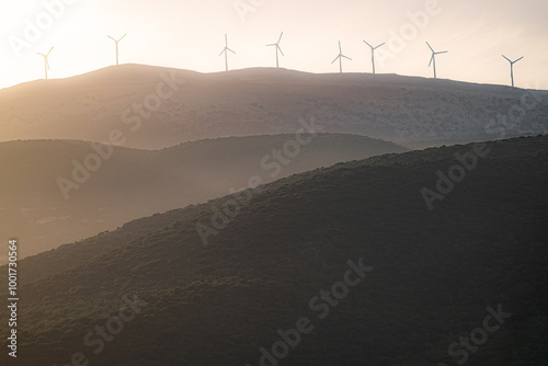 Wind turbines uppon hills at sunset