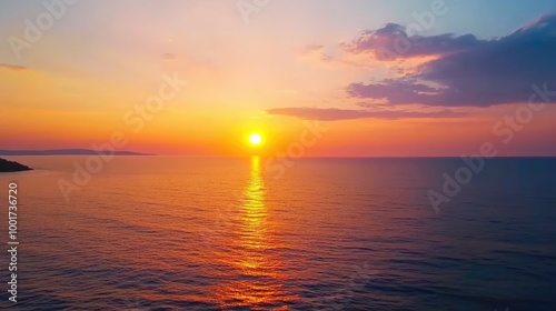 A vibrant sunrise over a calm ocean, with a golden sun just above the horizon, casting a warm glow on the water. 