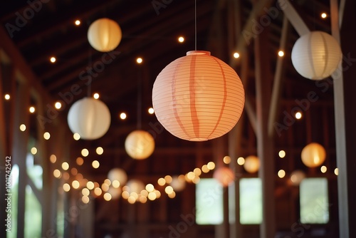 A room with many lit lanterns hanging from the ceiling. The lanterns are of different sizes and colors, creating a warm and inviting atmosphere