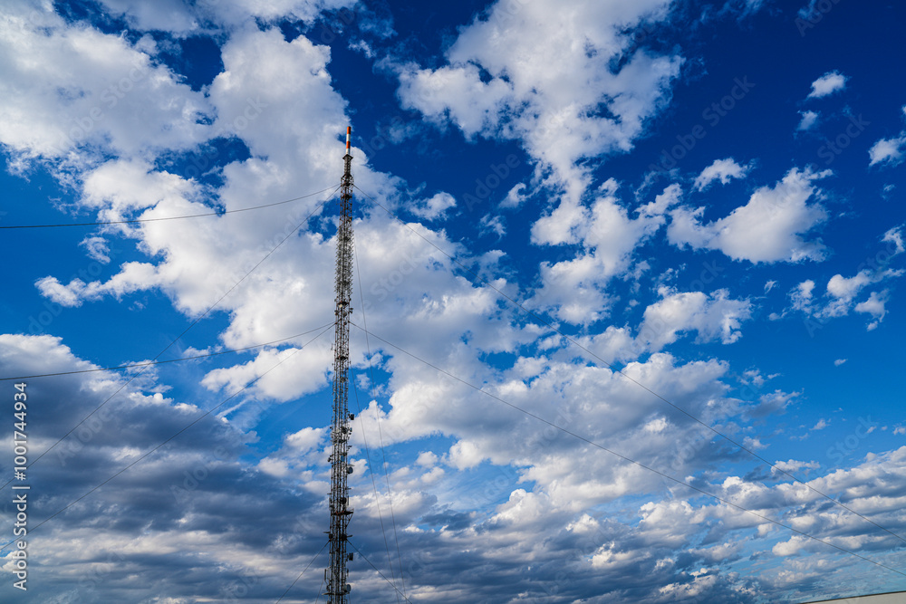 A cell phone antenna piercing the gorgeous cloudy sky A cell phone antenna piercing the gorgeous cloudy sky