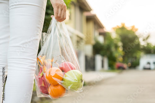 Woman hands carry in a plastic bag fruits on the way home. Hands holding plastic bags for shopping. Set zero waste plastic free concept. Sustainable lifestyle concept.