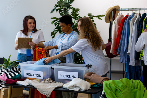 Concept of sustainable living, eco friendly planet saving, preserving textile pollution. Group of young volunteers sorting clothes for charity, recycling, donation. College university life, vintage photo