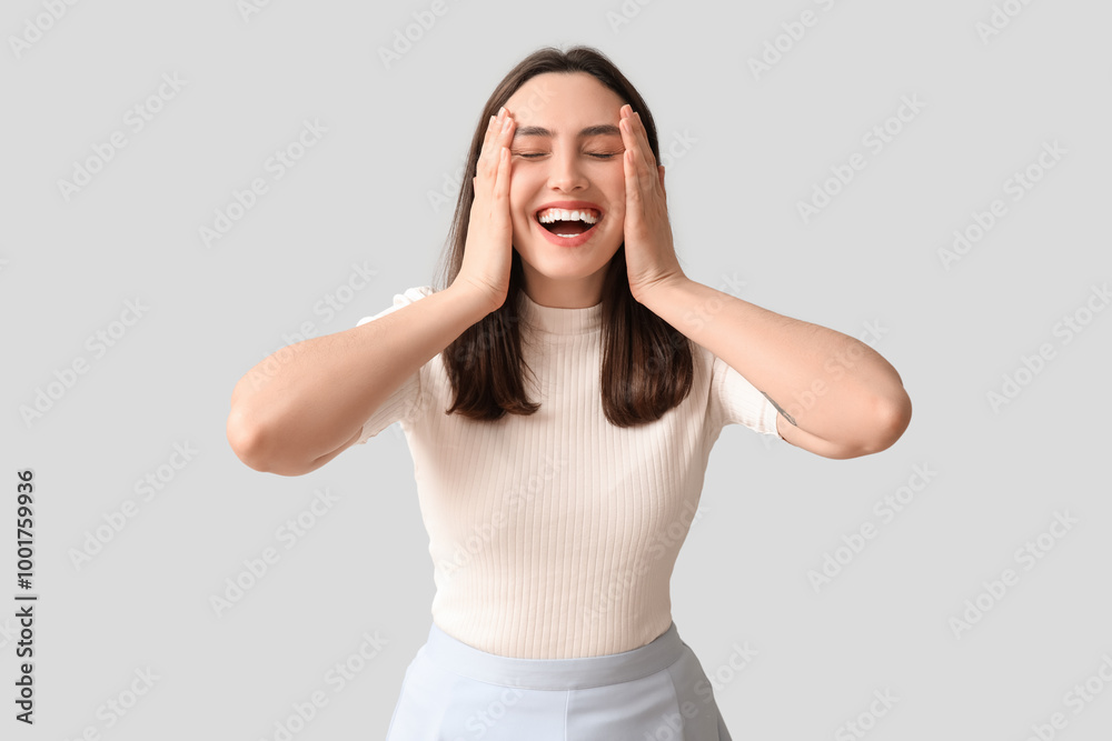 Smiling young woman on grey background