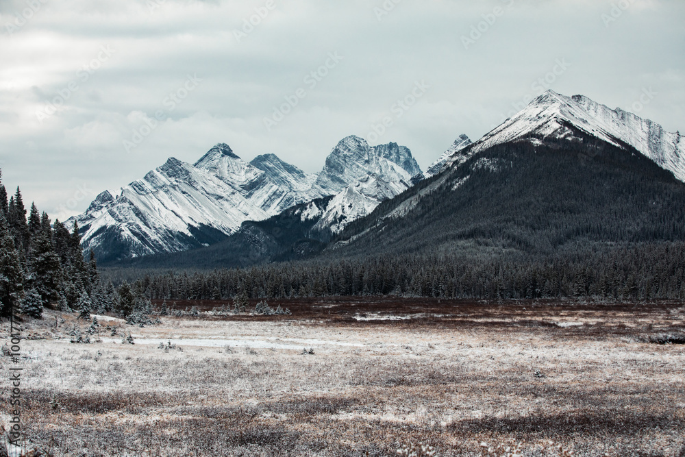 A breathtaking view of snow-capped mountains standing majestically beneath a cloudy sky, surrounded by a serene and untouched natural landscape during winter. A breathtaking view of snow-capped mountains standing majestically beneath a cloudy sky, surrounded by a serene and untouched natural landscape during winter.