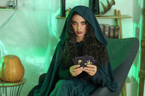 Young witch with tarot card...