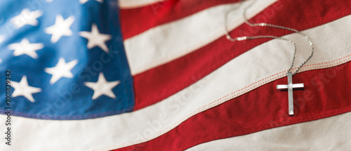 Christian cross necklace on American flag. For US Memorial Day, Veterans Day, USA memorial or military funeral. Representing honor and sacrifice of the armed forces from the United States of America. photo