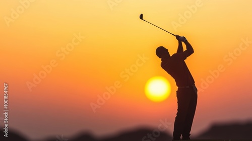 A golfer stands poised to swing, silhouetted against a stunning sunset filled with warm colors photo