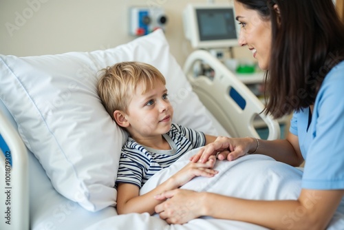 A nurse in a blue uniform gently holds hands with a boy in a striped shirt lying in a hospital bed, conveying care and compassion in healthcare.