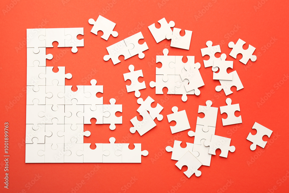White puzzle pieces on red background, top view