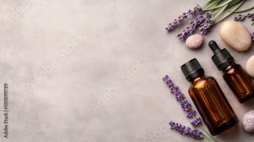 A calming display features lavender essential oil bottles alongside fresh lavender and smooth stones, enhancing a peaceful spa experience with ample copy space