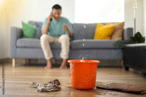 Young Asian Man Calling Complain Emergency Roof Leaking Damage Water Leak Or Flood From Ceiling
